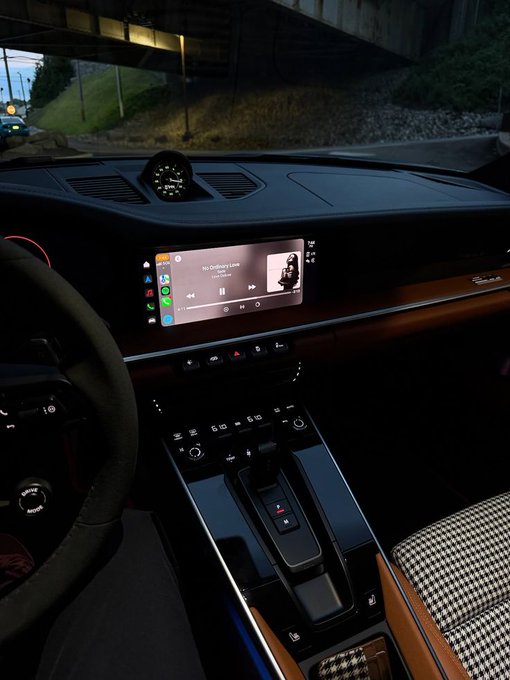 The image shows a car's interior with a dashboard that displays an MP3 player, possibly connected to a car stereo system. A person can be seen sitting inside the vehicle, likely preparing for their day or enjoying some music during a drive. The car is parked under a bridge, and there are trees visible in the background, suggesting it might be early morning or dusk when the sun is low on the horizon.

The post about the river implies that the person driving the car may have been listening to an uplifting song or podcast related to nature or the outdoors during their drive. The image captures a moment of daily life where someone has taken time for themselves and enjoyed some music while traveling through the city streets.