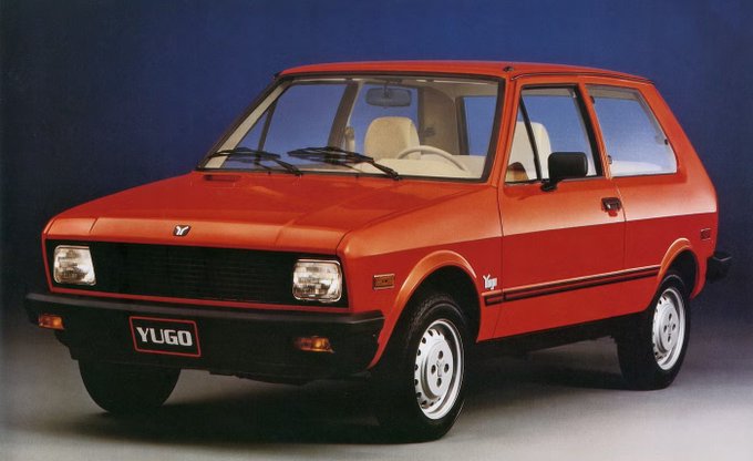 A promotional photo of a red Yugo hatchback car displayed against a blue background.