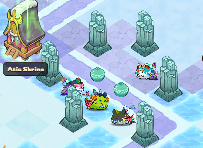 A screenshot from the mobile game Axie Infinity showing the 'Atia Shrine' location with various cute axie characters gathered around stone pillars on a watery path.