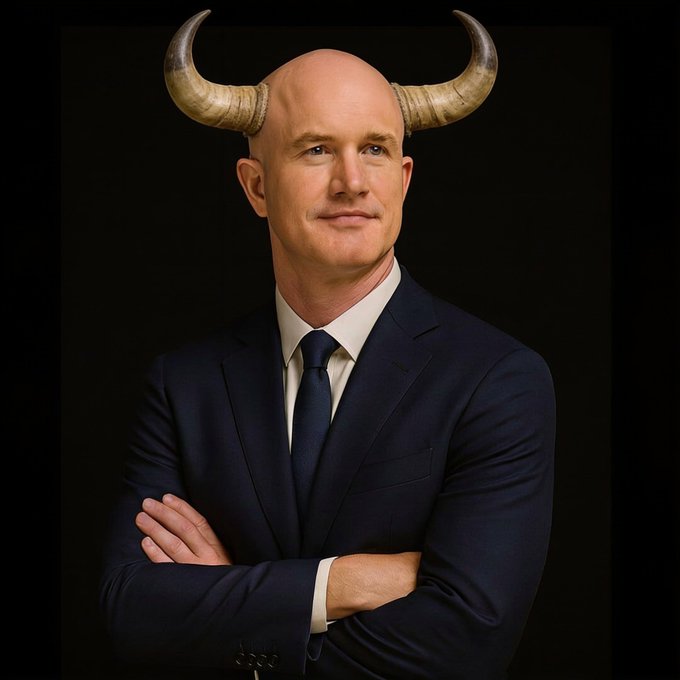 A confident bald man in a navy suit and tie poses with crossed arms against a dark background, sporting a pair of large bull horns on his head—visually punning on the post's "base bulls" greeting to project bullish market sentiment.