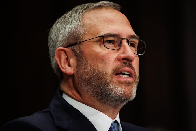 The image features a man wearing glasses and a suit talking to someone off-camera. The caption reads "INSANE: Brad Garlinghouse says as much as $10,000,000,000,000 could eventually move into 𝐴𝑡𝑖𝑒𝑙𝑟𝑠𝑡𝑘𝑛𝑡𝑚𝑜𝑡𝑖𝑎𝑡𝑖𝑛𝑔" and "focus on what is in the image and how it relates to the post." The man's facial expression suggests he might be discussing a serious topic, possibly related to cryptocurrency regulation.

The image also contains some text that reads "INSANE: Brad Garlinghouse says as much as $10,000,000,000,000 could eventually move into 𝐴𝑡𝑖𝑒𝑙𝑟𝑠𝑡𝑘𝑛𝑡𝑚𝑜𝑡𝑖𝑎𝑡𝑖𝑛𝑔" and "focus on what is in the image and how it relates to the post." The man's suit, glasses, and serious expression indicate that he might be discussing a complex or controversial topic.