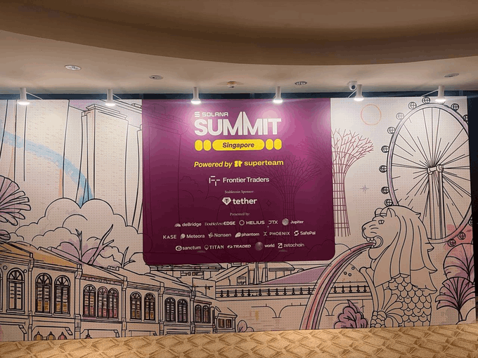 A purple banner for the 'SOLANA SUMMIT Singapore' event is mounted on a wall featuring line art of Singaporean landmarks, listing sponsors like FrontierTraders, tether, and Helius.