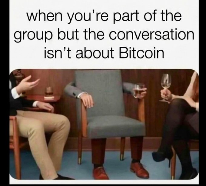 The meme shows three people seated, with the middle person notably having no visible head/face, holding a wine glass, with text reading "when you're part of the group but the conversation isn't about Bitcoin." 

The caption "guess I'll just sit here then" fits perfectly with the image, as the headless middle figure humorously represents someone who's lost their identity or connection to the group when their favorite topic (Bitcoin) isn't being discussed, leaving them sitting in awkward silence.