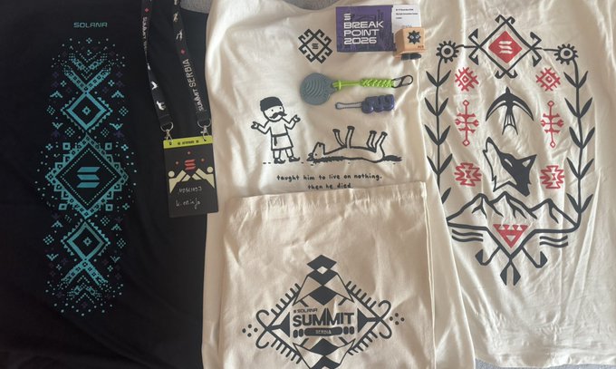 A collection of t-shirts and merchandise including a 'SOLANA' shirt, a 'BREAK POINT 2025' shirt with a cartoon man and dog, a 'SUMMIT 2023' shirt, and items featuring fox and mountain designs.