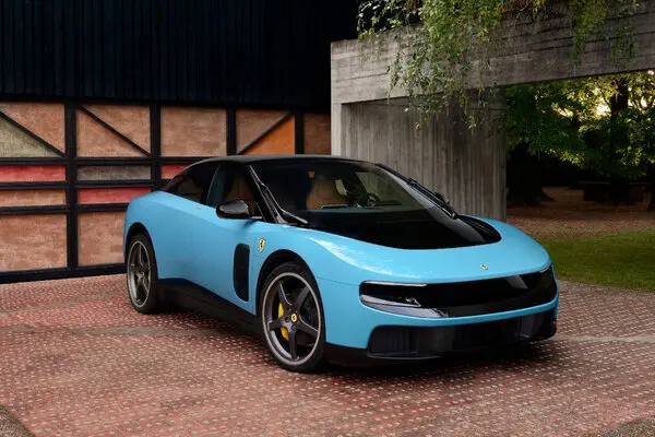 The image features a blue sports car with black accents parked outside of a building. The car has a large windshield and a sleek design, making it an eye-catching sight. The car's color scheme includes shades of blue and black, which adds to its overall appeal. The car is positioned in front of a brick wall, creating a contrast between the modern vehicle and the traditional building structure. In the background, there are trees that provide a natural element to the scene. The image also contains text related to the sale of the Ferrari sports car for Bitcoin, indicating that it's available as an investment opportunity or possibly even as a gift.