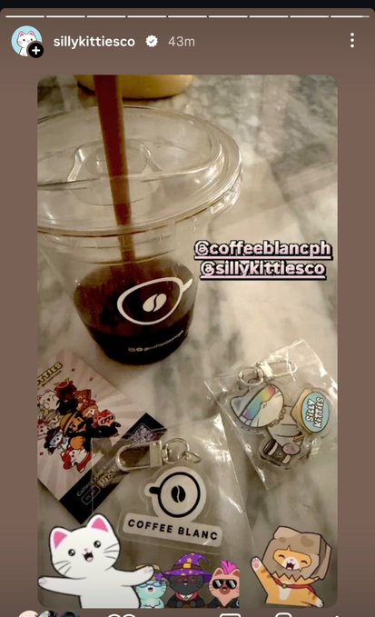 An Instagram story from 'sillykittiesco' posted 43 minutes ago, showing an iced coffee from 'coffeeblancph' alongside various merchandise like stickers, pins, and a maneki-neko keychain.