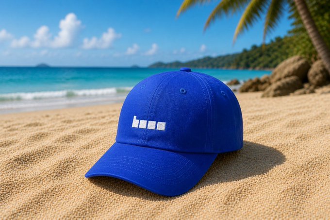 A blue "base" baseball cap rests on a sandy tropical beach with turquoise waters and palm trees in the background, symbolizing the caption's message of unwavering commitment to building on Base regardless of location—whether at the beach, traveling, or working. The relaxed seaside setting visually reinforces the "travel days" aspect of the post, while the bold branded cap represents the conviction of choosing Base as the onchain home.