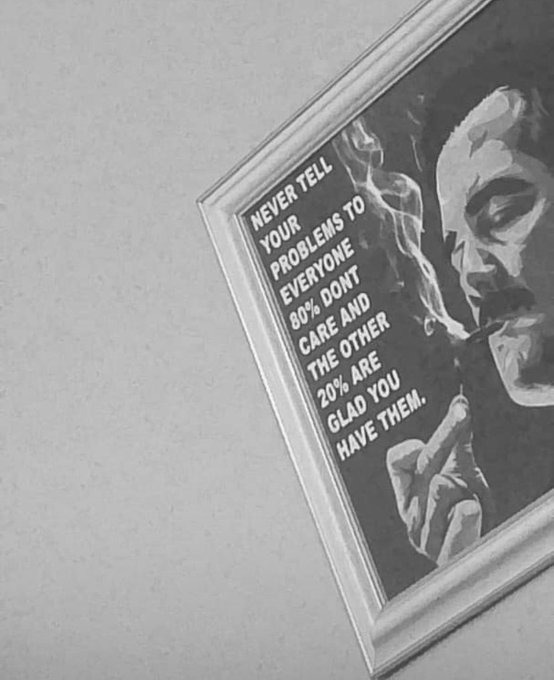 A black-and-white framed poster featuring a smoking man in shadow with the quote: "NEVER TELL YOUR PROBLEMS TO EVERYONE. 80% DON'T CARE AND THE OTHER 20% ARE GLAD YOU HAVE THEM."