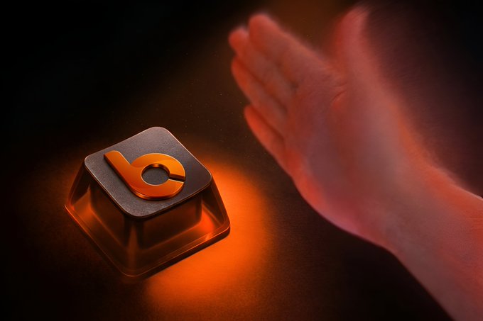 A hand reaching toward a glowing orange keycap featuring a stylized logo, visually echoing the "Press to tokenise" call to action as if tapping the key will trigger digital asset creation.