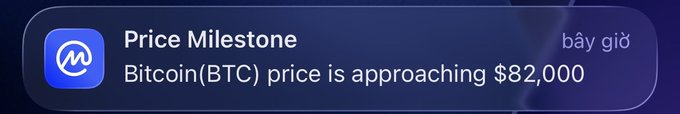 A smartphone notification alerts that Bitcoin (BTC) price is approaching $82,000, marked as a "Price Milestone" with a "bây giờ" (Vietnamese for "now") timestamp, aligning with the post celebrating Bitcoin reaching the $82K mark.