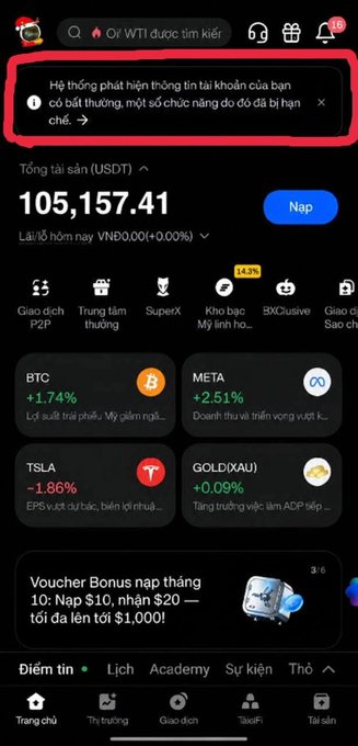 A smartphone screenshot shows a Binance-like crypto wallet displaying “105,157.41” USDT and an alert reading “Hệ thống phát hiện thông tin tài khoản của bạn có bất thường, một số chức năng do đó đã bị hạn chế.” Visible tickers include BTC, META, TSLA, and GOLD(XAU), alongside a voucher banner offering up to $1,000; this restriction notice visually supports the post’s claim that the account was locked shortly after transferring about 2 billion VND from Huobi to BingX.