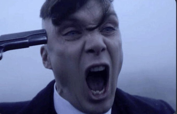 A close-up shot captures a man with a gun pressed against his head, his mouth open in a scream.
