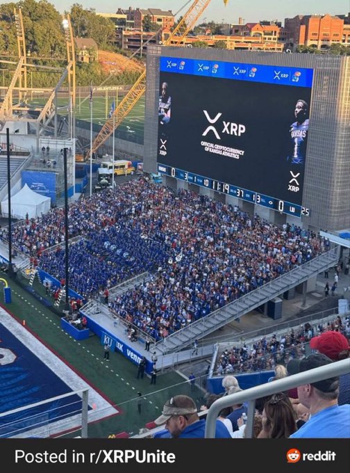 A stadium screenshot posted in r/XRPUnite showing a crowd watching a game where the scoreboard prominently displays the XRP logo as the official cryptocurrency of Armada.