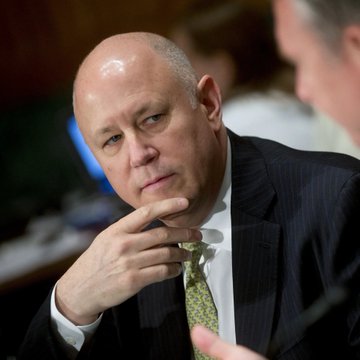 The image features a bald man wearing a suit and tie, with his hand resting on his chin while he looks off into the distance. The background shows another person sitting at a desk, which could be an office setting or a conference room. The caption reads "LATEST: Jeffrey Sprecher, the CEO of Intercontinental Exchange (ICE), said at a Bernstein conference that the decentralized crypto derivatives platform Hyperliquid is “bigger than Nasdaq” in trading activity and praised its small core team as “very, very smart people.”". The image seems to be related to Jeffrey Sprecher's statement about the cryptocurrency market, with the focus on his words and the context of a business meeting or conference setting.