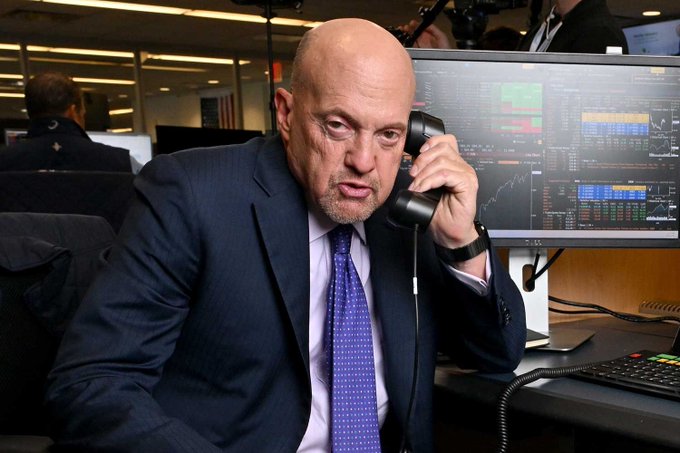 Jim Cramer, host of CNBC's Mad Money, speaks on a phone while monitoring stock charts in his newsroom, an ironic backdrop given his recent bearish call on Bitcoin over quantum computing concerns—just before BTC surged from ~$62,300 to ~$86,000, cementing another "Inverse Cramer" moment.