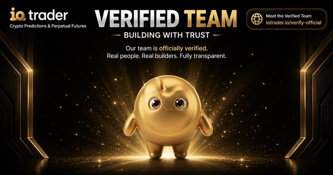 The image is a promotional banner from iotrader, featuring their golden mascot character against a dark, glowing background, with the text "VERIFIED TEAM - BUILDING WITH TRUST" and a note stating "Our team is officially verified. Real people. Real builders. Fully transparent." A call-to-action button directs viewers to iotrader.io/verify-official, reinforcing the accompanying security notice about verifying the official IO Trader team to prevent impersonation scams.
