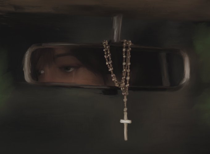 A moody, dark photograph of a person's eye reflected in a car's rearview mirror, with a rosary bearing a cross hanging from the mirror.