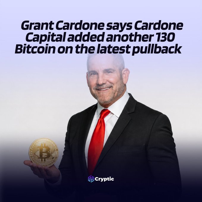 The image features a man dressed in a suit, holding up a gold coin with a smile on his face. The caption below the image reads "Grant Cardone says Cardone Capital added another 130 Bitcoin on the latest pullback". This suggests that there is an ongoing discussion or trend related to Bitcoin and its value among institutional investors.