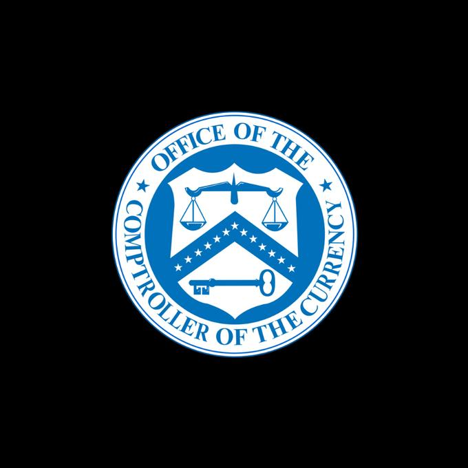 The image displays the official seal of the "Office of the Comptroller of the Currency" in blue and white, featuring a shield with scales of justice, stars, and a key. This emblem represents the U.S. federal banking regulator mentioned in the announcement about developing a regulatory framework for payment stablecoin issuers.