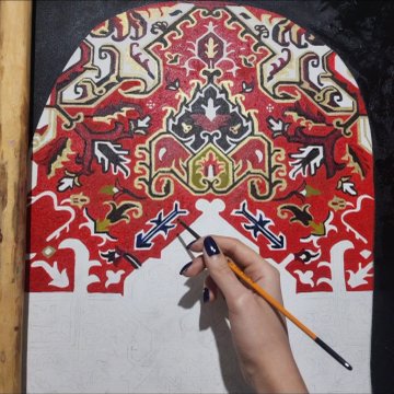 A hand paints intricate red, gold, and black floral patterns onto an arched canvas, with outlined shapes below waiting to be filled in.