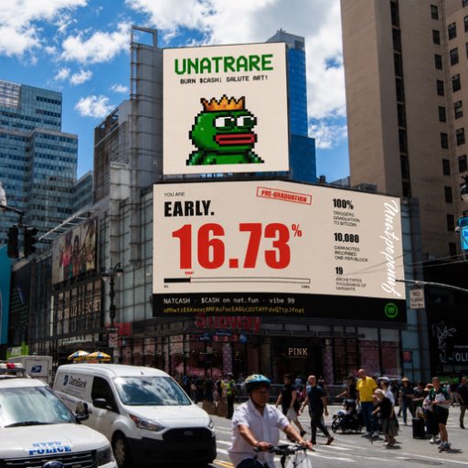 The main focus of the image is a city street scene where several people are walking down the sidewalk, some using bicycles while others walk with luggage. There's also a traffic light visible among the pedestrians. On top of buildings, there are two billboards advertising different products such as "UNATRARE" and "early: 16.73%", potentially offering discounts or promotions to those who spend time on this street. The image does not provide any information about the website or platform hosting these advertisements but it is clear that the location appears to be a busy urban area with people engaged in various activities such as shopping, walking their bikes, and commuting by car.