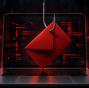 A red phishing envelope hangs from a fishing hook in front of a laptop screen, symbolizing a phishing attack. The image illustrates a Trezor security alert warning that hackers have breached their email provider and are sending fake "STM32 Entropy Vulnerability" emails to steal users' recovery phrases.