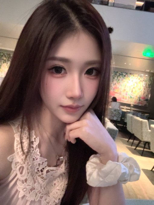 A young woman with long dark hair poses in a white lace top, smiling softly at the camera in what appears to be an upscale restaurant or lounge setting. The image accompanies a post celebrating Qixi (Chinese Valentine's Day), where the woman shares her joy about receiving a stock ($SPCX) gift from her generous boss at MSX, highlighting both the thoughtful gesture and her appreciation for the holiday.