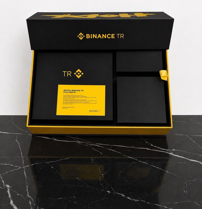 A sleek black and gold Binance TR gift box displayed on a black marble surface, featuring the Binance logo, a "TR" branded card reading "SEVGİLİ BİNANCE.TR KULLANICISI" (Dear Binance.TR User), and an empty compartment for a gift. The image showcases the premium presentation accompanying a gift received from the Binance TR team.