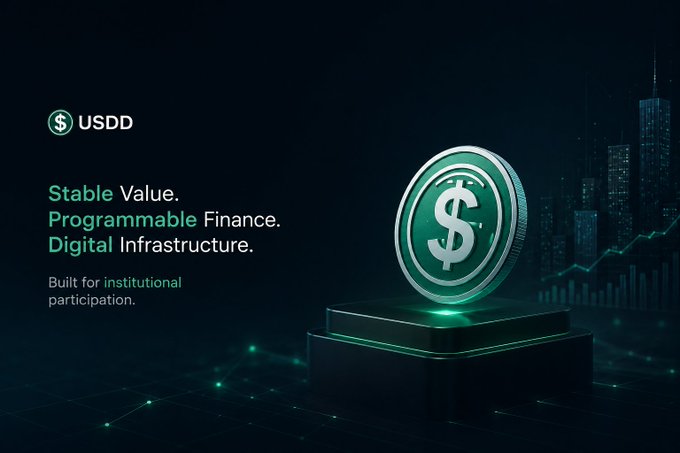 A promotional graphic for USDD cryptocurrency featuring a glowing green dollar coin on a pedestal, with text reading 'Stable Value. Programmable Finance. Digital Infrastructure. Built for institutional participation.' against a dark cityscape background.