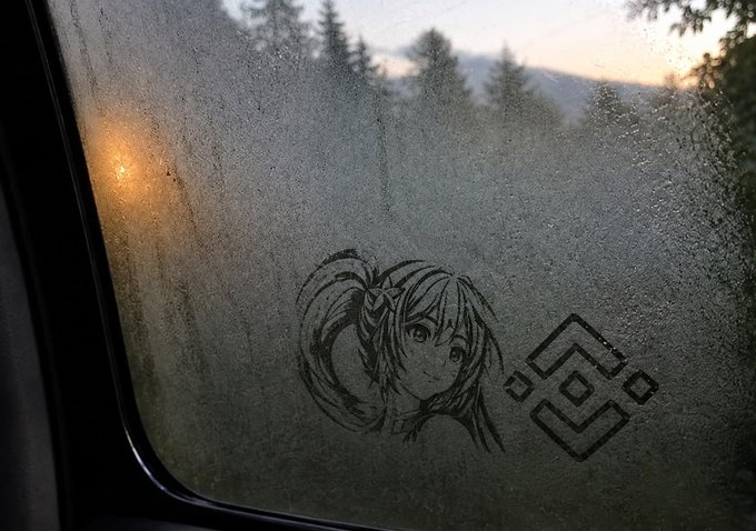 A fogged-up window reveals a drawing of an anime character (Asuna from Sword Art Online) alongside the SAO logo, with a sunset visible through the condensation.