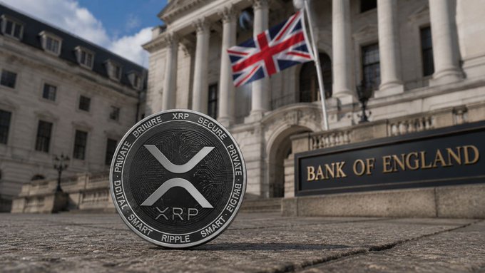 A silver XRP (Ripple) cryptocurrency coin rests on cobblestones in front of the Bank of England, with the Union Jack flag flying above the iconic neoclassical building—visually tying the digital asset to the UK's push to accelerate digital-currency and stablecoin innovation.