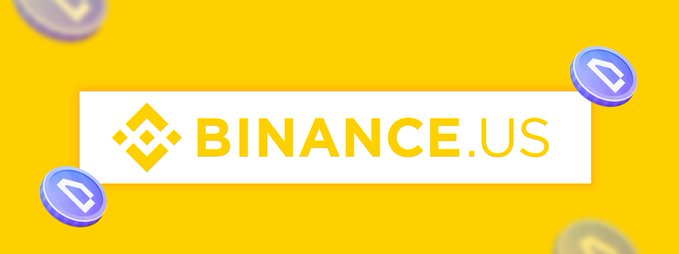 The image features a banner with the text "Binance.US" written in white letters against a yellow background. The banner also includes three blue coins floating around it, adding visual interest to the design. The caption below the banner reads "WOD will be listed on Binance US! Congrats to @worldofdypians As one of the top dApps on @BNBCHAIN , they’ve never stopped building and consistently pushing updates."