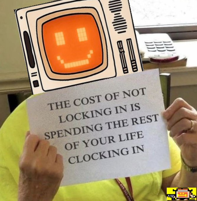 A person wearing a TV-head mask holds a sign reading 'THE COST OF NOT LOCKING IN IS SPENDING THE REST OF YOUR LIFE CLOCKING IN'.