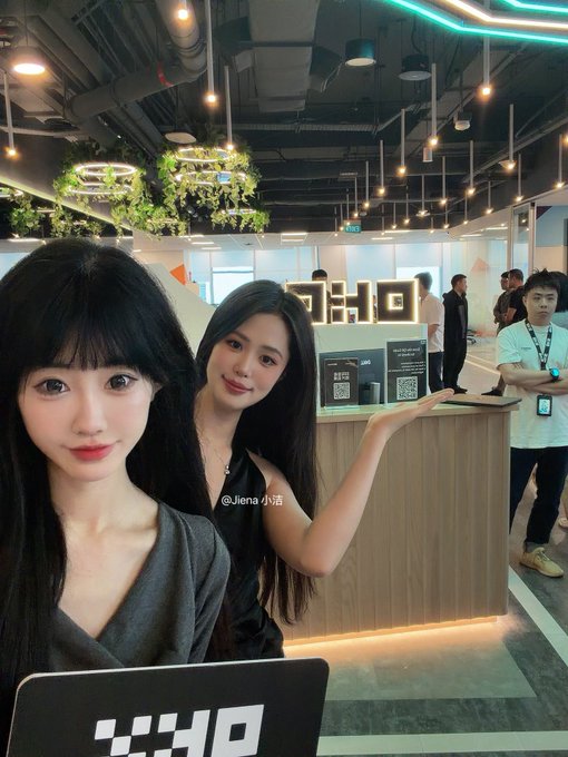 Two young women taking a selfie in what appears to be an office lobby with the watermark '@lena小语' visible.