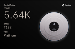 The image shows a close-up of a white CD with a black center, placed against a black background. The text "Còn build Decibel là đân triết đã từng nói" is visible in the image. This information suggests that the CD might be related to the post about building a website or developing a new software, as it features a white CD with a black center and text on it.