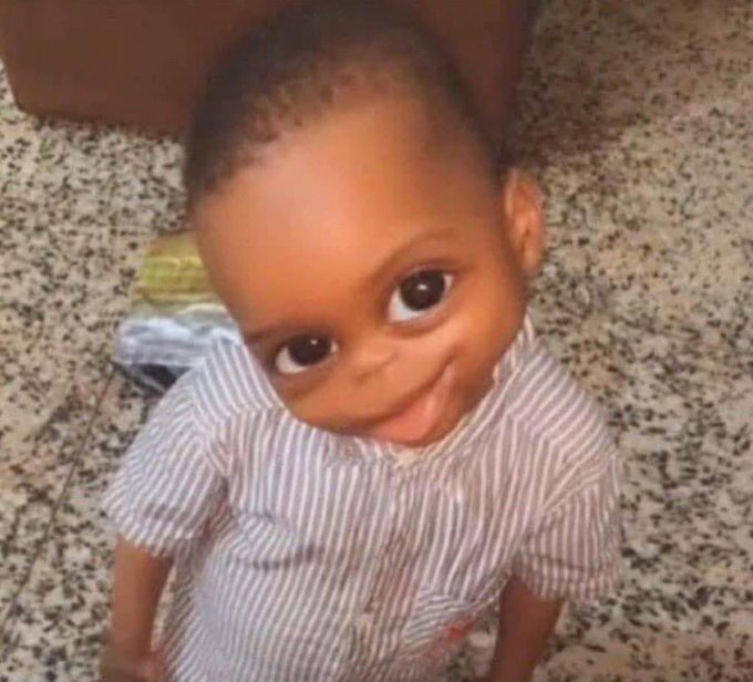 A young child smiles up at the camera while sitting on a tiled floor, wearing a striped shirt. The post's skeptical question about believing in "$ANSEM" versus just wanting an airdrop is humorously paired with this image, implying the "believers" are naive like a baby, only in it for freebies rather than genuine conviction.