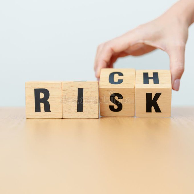 A hand rotates wooden blocks to change the word 'RISK' to 'CSK' (or back), symbolizing risk in decision-making or finance.