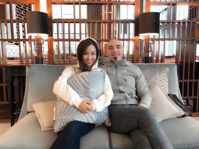A smiling couple sits together on a gray couch in a warmly lit lounge, with the woman holding a striped pillow and the man in a gray hoodie, posing comfortably in what appears to be a hotel or upscale lobby setting.

The image captures a tender, happier moment between the couple, contrasting with the post's somber reflection on the loss of a long-trusted friend, Stefano, perhaps highlighting the preciousness of genuine human connections and the difficulty of finding such trust in the crypto industry.