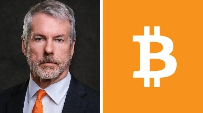 The image shows a man wearing a tie with the letter "B" printed on his shirt, accompanied by an orange square that displays the word "Bitcoin" surrounded by white capital letters. The background of the photo is black and sets the stage for the main visual element, which features the man's face in profile view at the top side of the image.