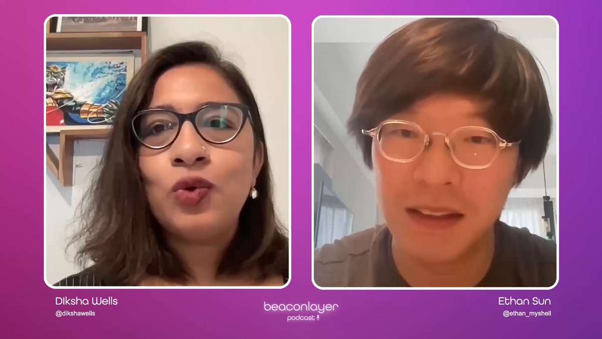 The image shows two people sitting next to each other with their faces displayed on a computer screen. The person on the left has dark hair and glasses, while the person on the right has short brown hair and also wears glasses. They appear to be engaged in an online conversation or video call.