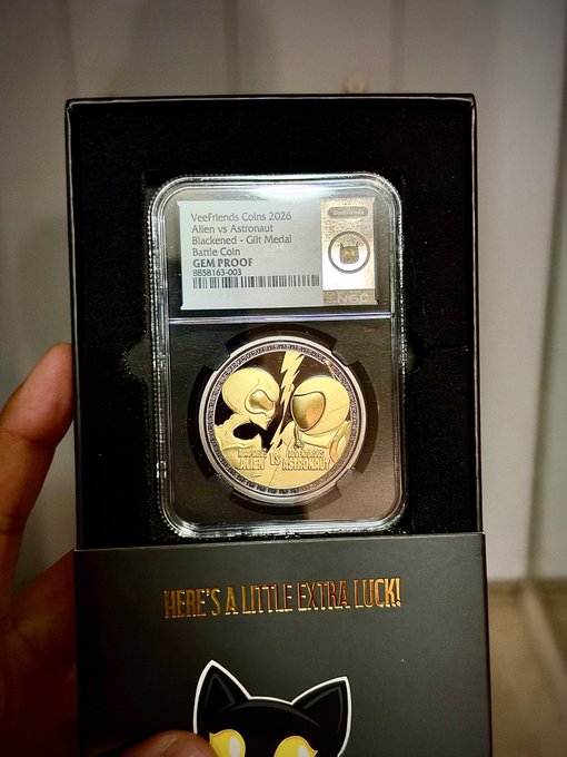 A hand holds a graded NGC coin in a black presentation box labeled “VectFriends Coins 2026,” “Alien vs Astronaut,” “Black Panther - Chill Metal,” “Battle Coin,” “GEM PROOF,” “MINTED 16,000,” and “HERE’S A LITTLE EXTRA LUCK!”