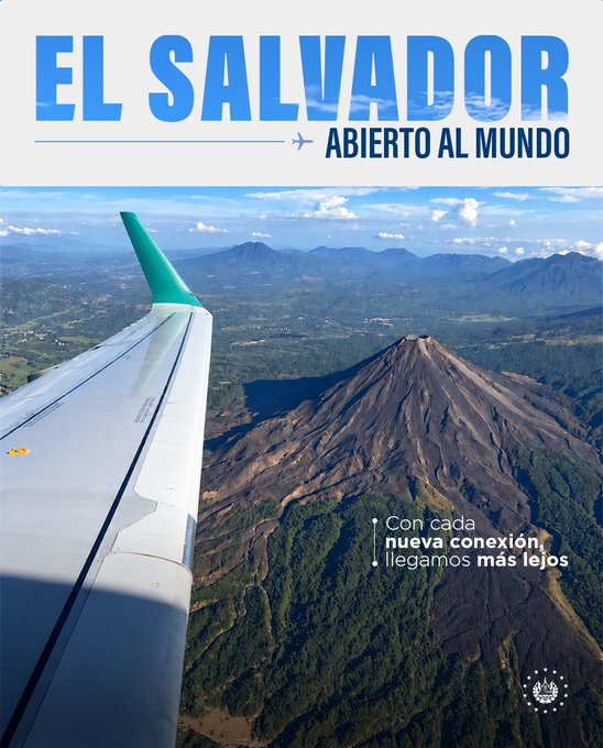 An aerial photo taken from an airplane window shows a dramatic view of a volcanic landscape in El Salvador, with the plane's wing prominently in the foreground, overlaid with the text "EL SALVADOR ABIERTO AL MUNDO" and "Con cada nueva conexión, llegamos más lejos" (With each new connection, we go further), visually promoting the country's new direct flights from Madrid and Barcelona to support tourism during Bitcoin Month.