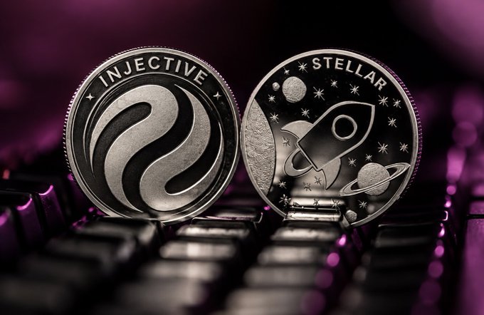 Two metallic cryptocurrency coins stand on a keyboard, labeled “INJECTIVE” and “STELLAR,” with purple lighting in the background.