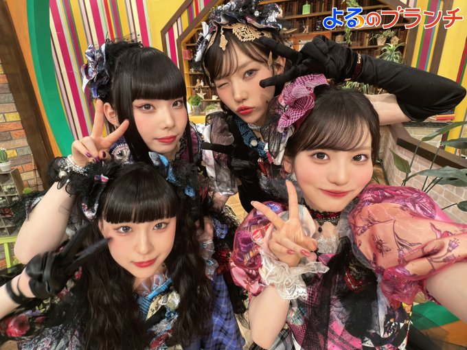 The image features four girls with long hair wearing colorful headbands and posing for a photo together. They are all smiling, indicating that they might be excited about an upcoming event or celebration related to Theta music.