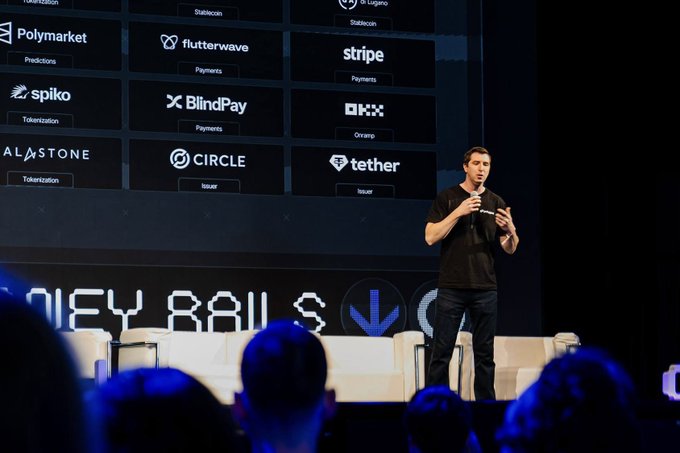 Polygon's CPO John Egan presents on stage at Money 20/20, with a backdrop displaying key payment partners including Polymarket, Stripe, Flutterwave, Tether, Circle, BlindPay, Spiko, OKX, and Stablecoin, illustrating Polygon's expanding role in payments and stablecoin infrastructure for AI-driven financial systems.