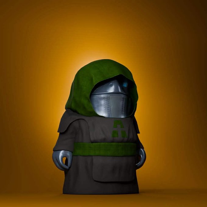 A figurine or toy character wearing a dark robe with green hood and accents, featuring a metallic robotic face with blue glowing eyes against an orange background.