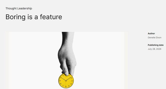 A webpage header titled 'Boring is a feature' under the category 'Thought Leadership,' authored by Denelle Dixon, published July 28, 2026, featuring a black-and-white image of a hand holding a yellow clock.