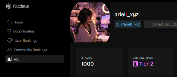 A user's Nucleus profile showing username "ariell_xyz" with an AURA balance of 1000 and an Overall Rank of Tier 2, which contextualizes the post's discussion of $AURA as a platform currency used within the Nucleus ecosystem.