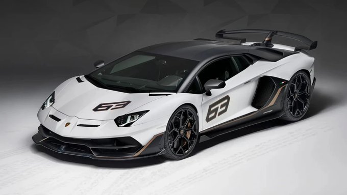A white Lamborghini Aventador SVJ 63 with the number "63" displayed prominently on its hood and side is featured against a dark studio background. The image showcases the limited-edition supercar referenced in the caption, highlighting its sleek aerodynamic design, large rear wing, and gold-accented wheels.