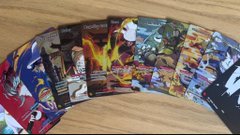A fan fanned out their collection of Azuki trading cards across a wooden surface, showcasing the colorful artwork that coincides with the post's surprise about Azuki's pivot into the TCG space.
